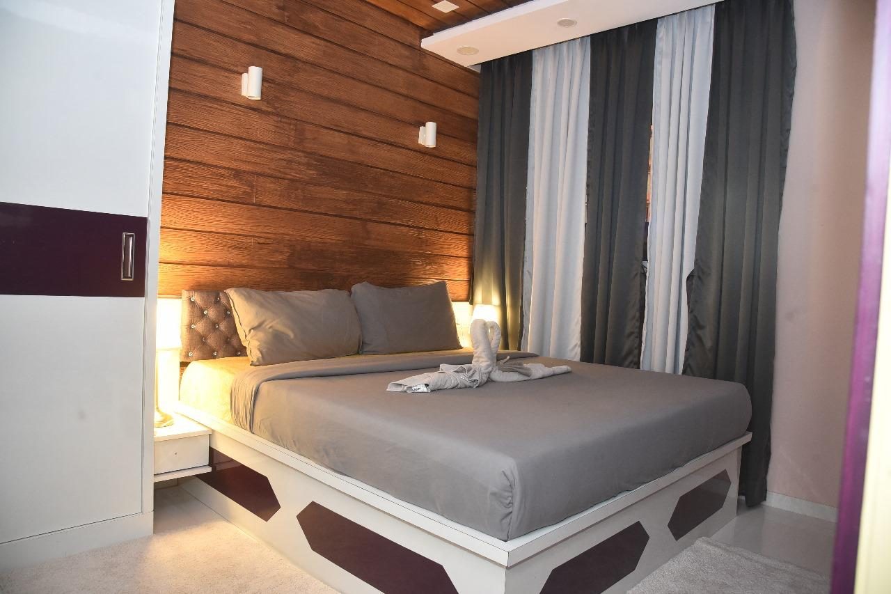 A bedroom with a slatted wood wall